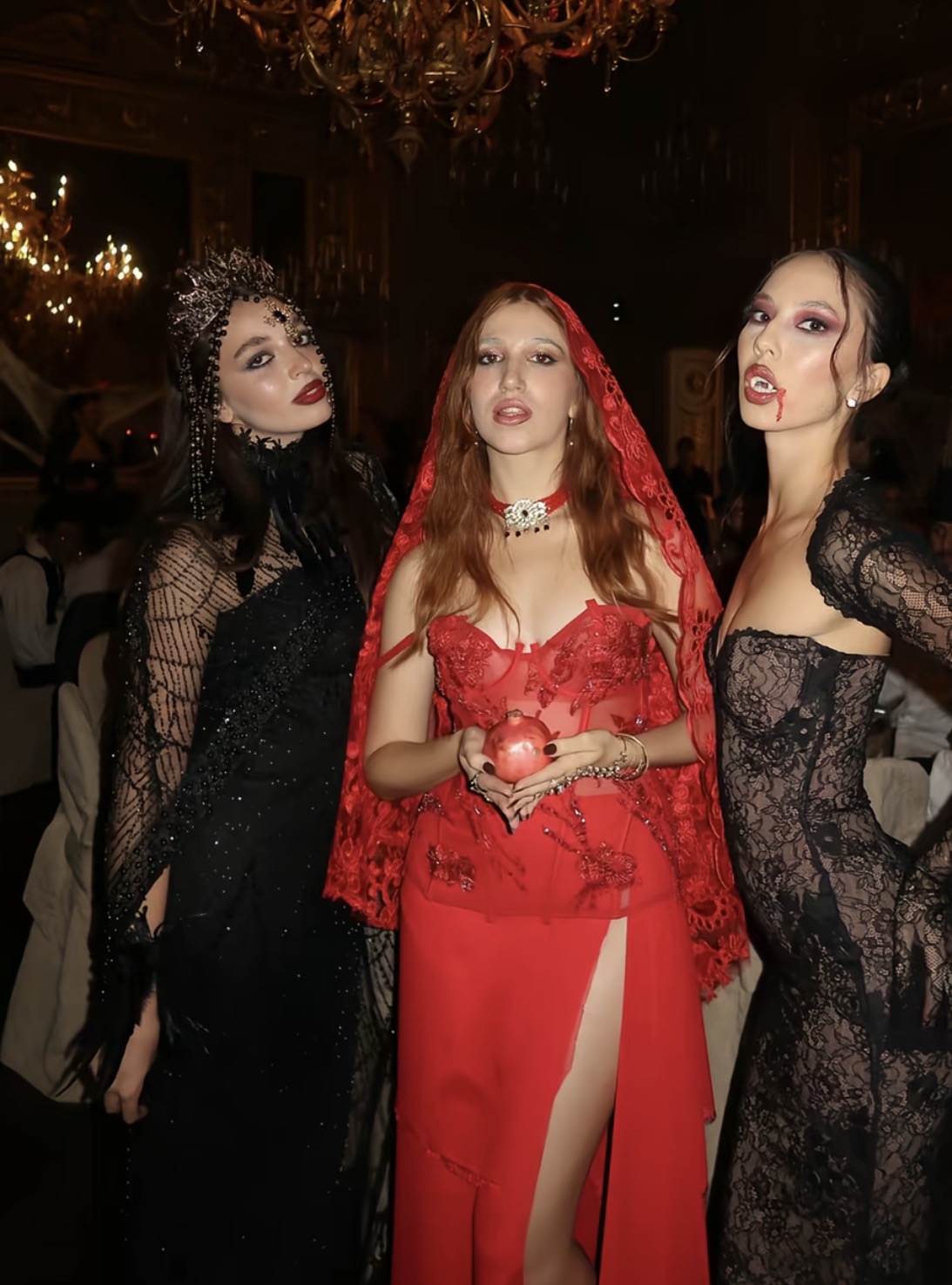 Abiti da sera scuri e rossi con pizzi, corone e trucco dark
